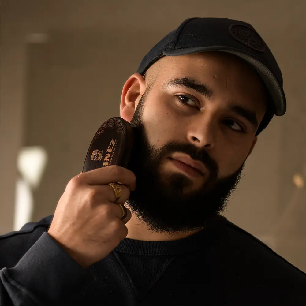Een man die zijn baard borstelt met een baardborstel.